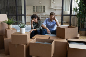 Tired,Unhappy,Young,Caucasian,Couple,Sit,On,Sofa,In,New
